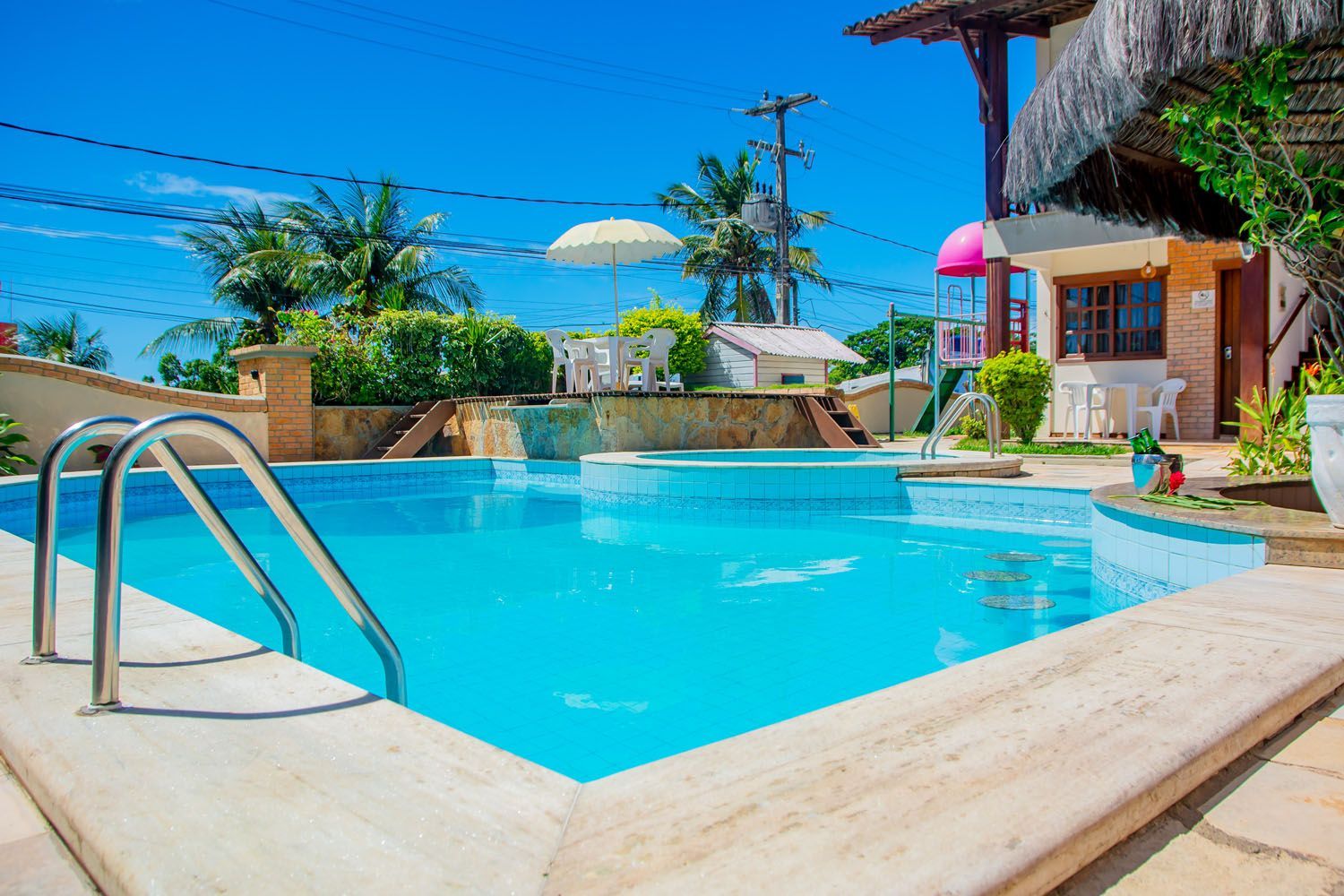 Uma grande piscina com escadas que conduzem a ela em frente a uma casa.