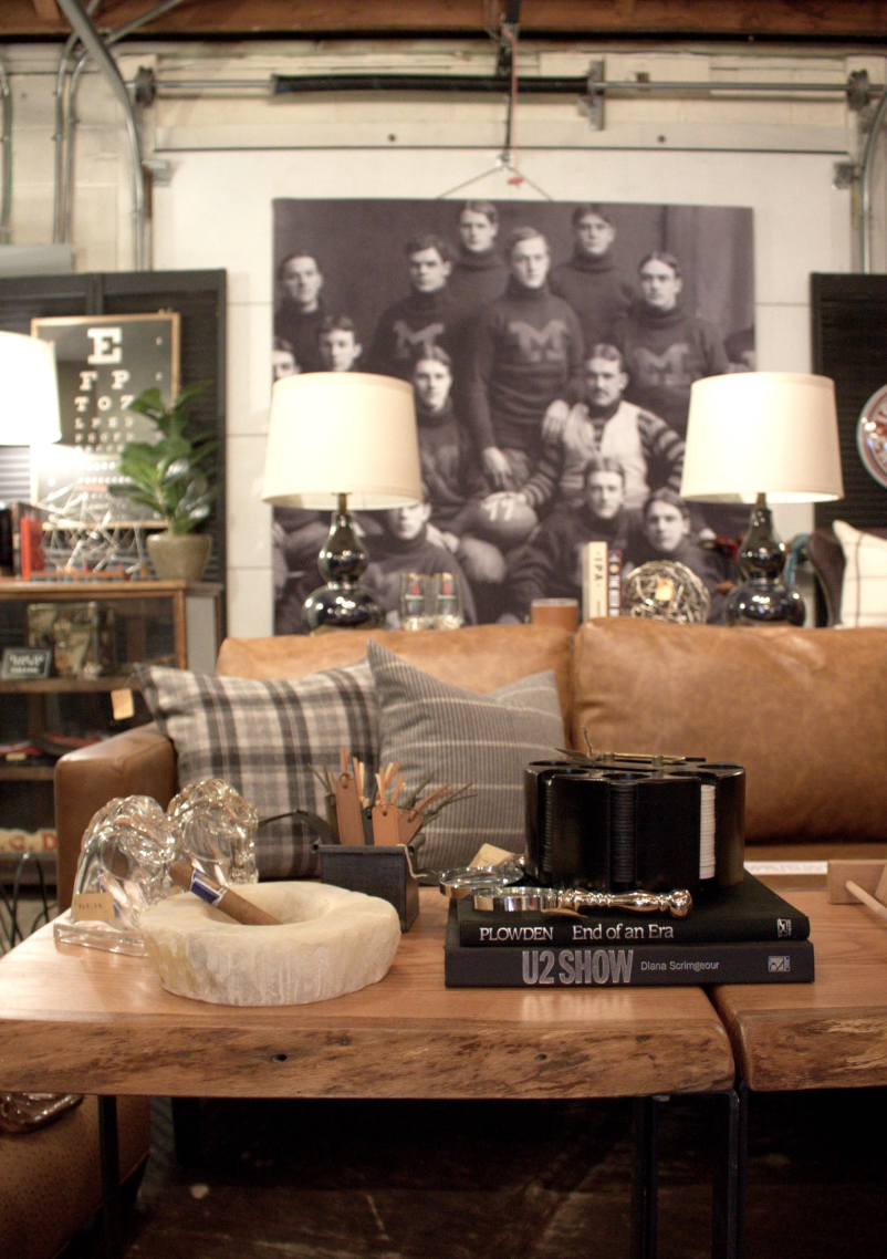 A living room with a couch and lamps and a picture of a group of people on the wall