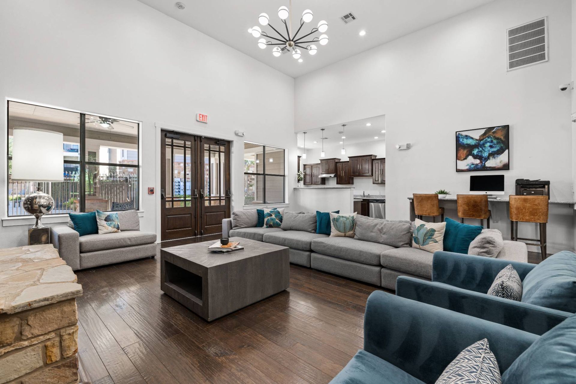 Spacious modern lobby lounge with a large gray sectional and bar-height kitchen area.