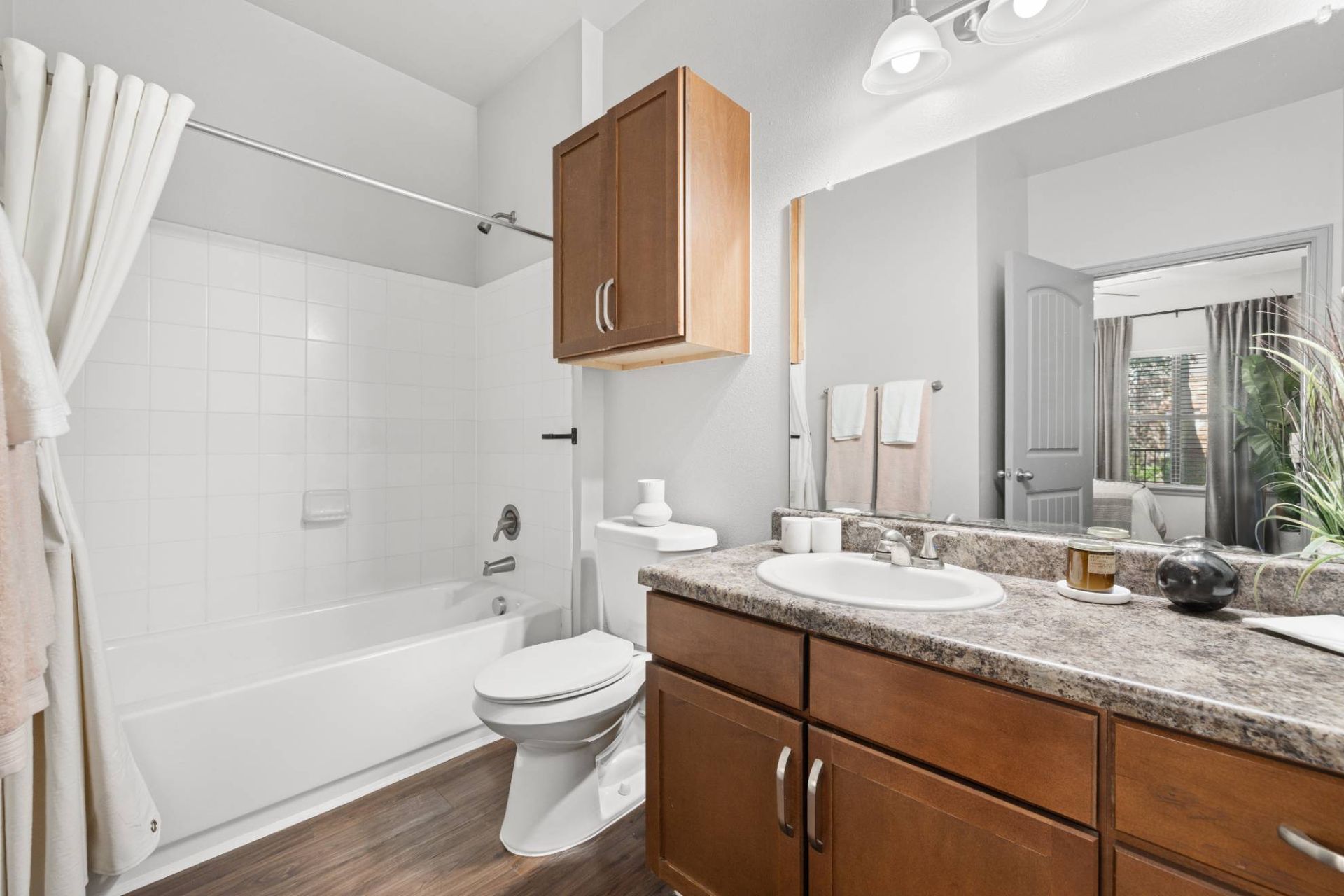 Bathroom in an apartment with vanity, sink, toilet, and tub/shower.