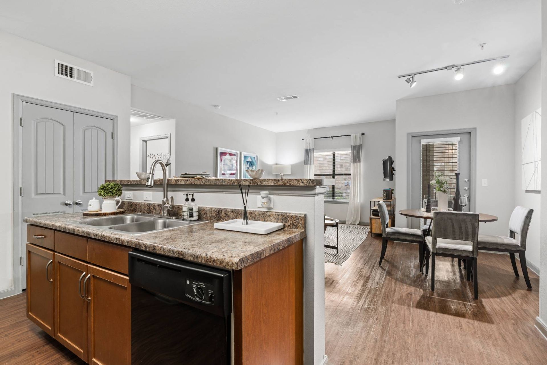 Open-concept kitchen with granite counters and double sink, bar seating, opening to living/dining area.