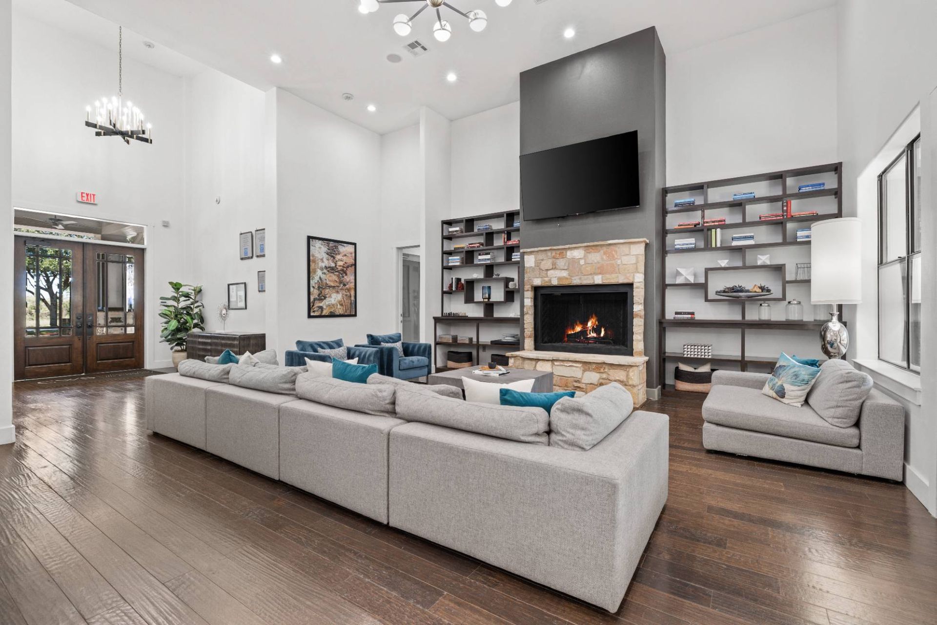 Spacious modern apartment living room with stone fireplace, built-in shelves, and a large sectional.