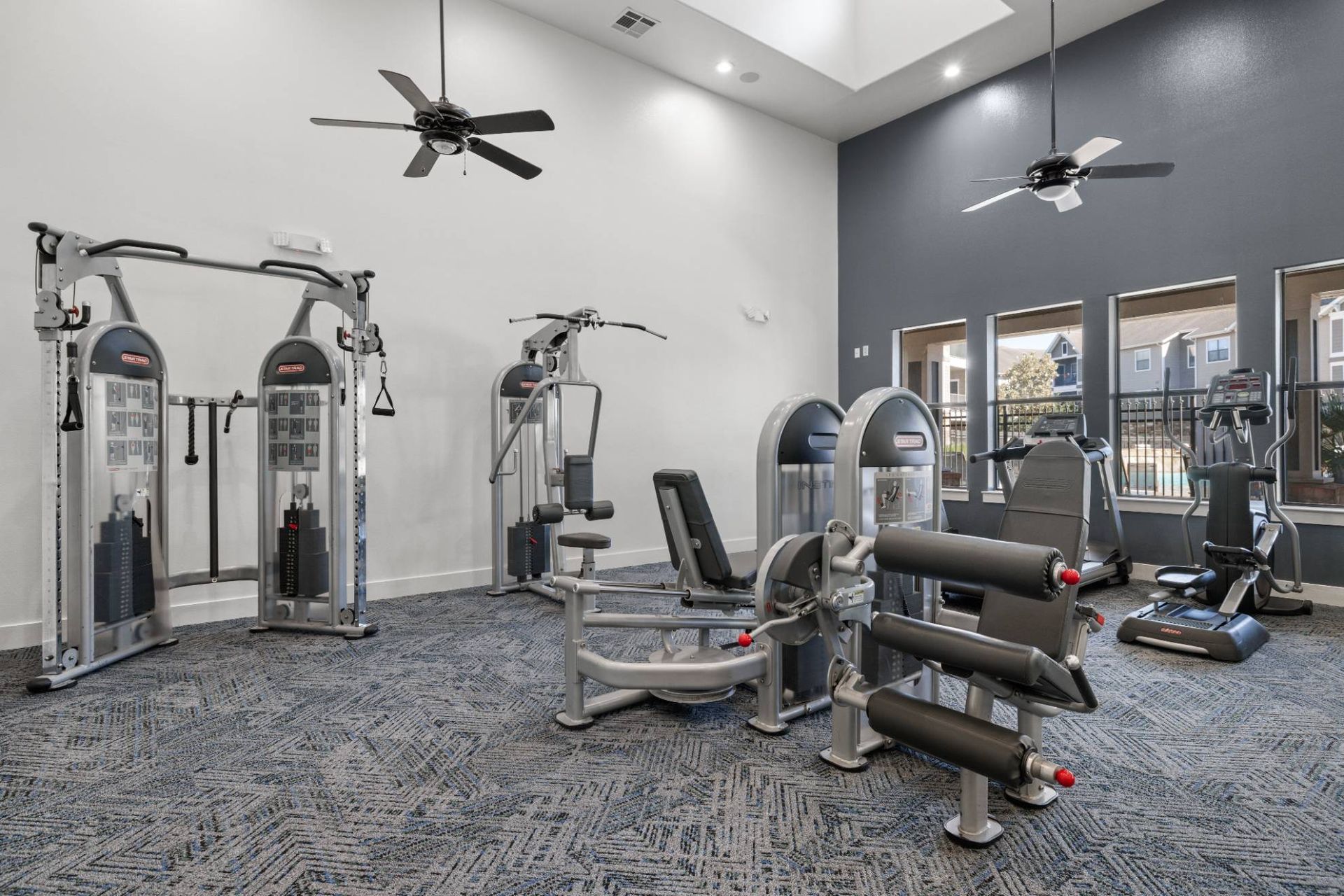 Interior view of a modern gym with cardio machines and weight stations
