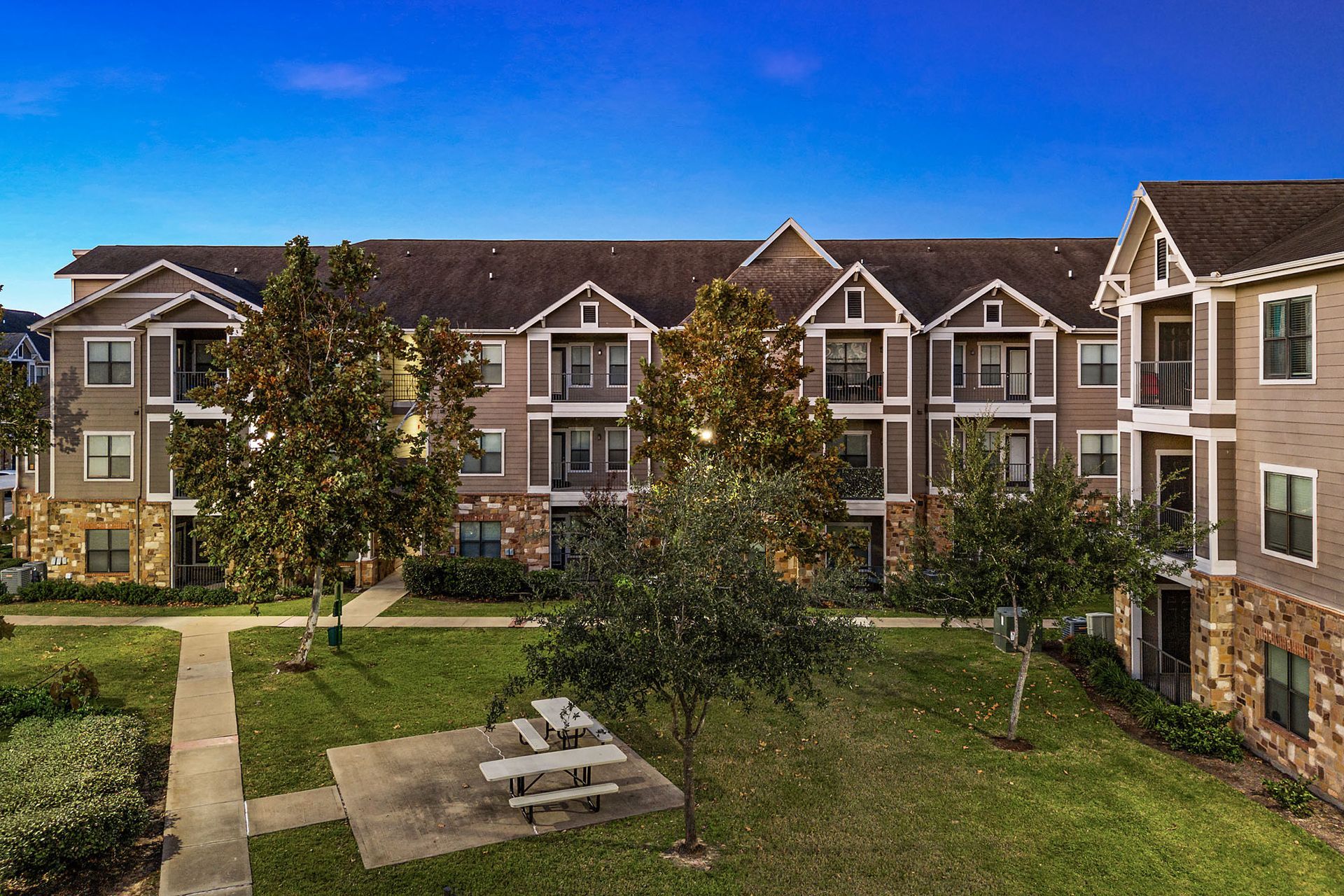 Open grassy courtyard featuring picnic tables for outdoor dining and relaxation.