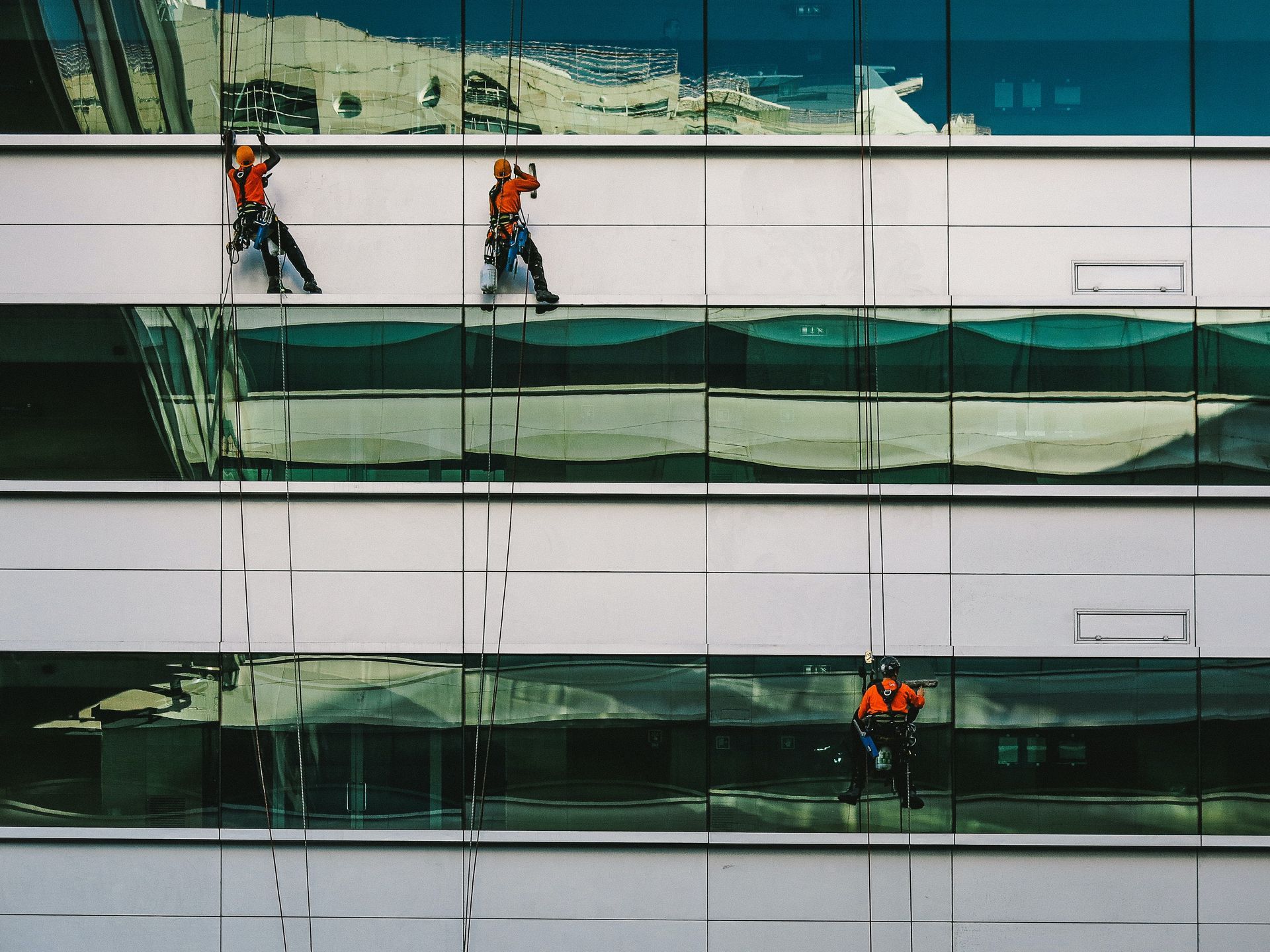 Window cleaner diligently washing the exterior of a tall building, ensuring a crystal-clear view.