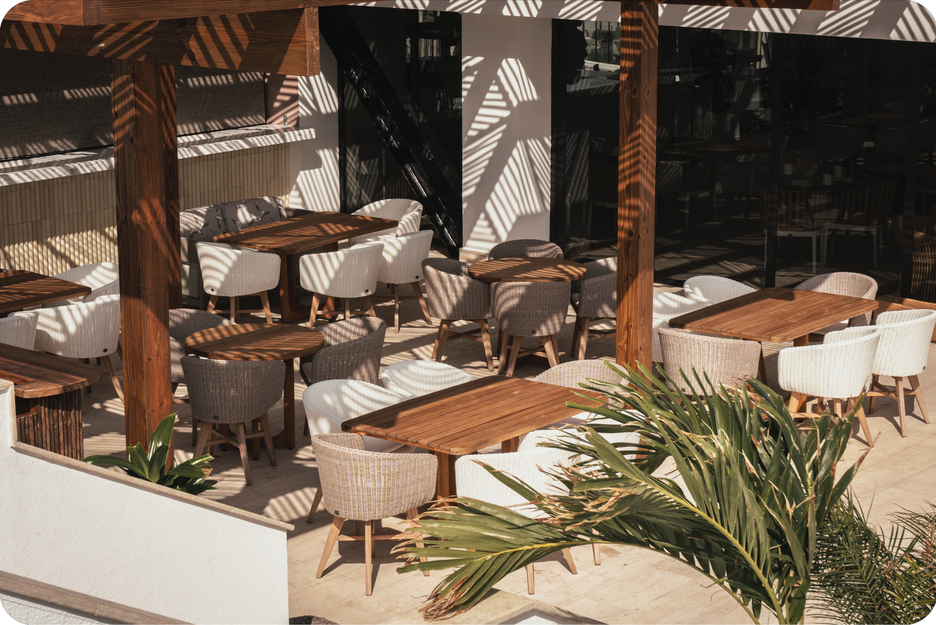 Zona interior con mesas, sillas y vegetación decorativa en un hotel en San Andrés.