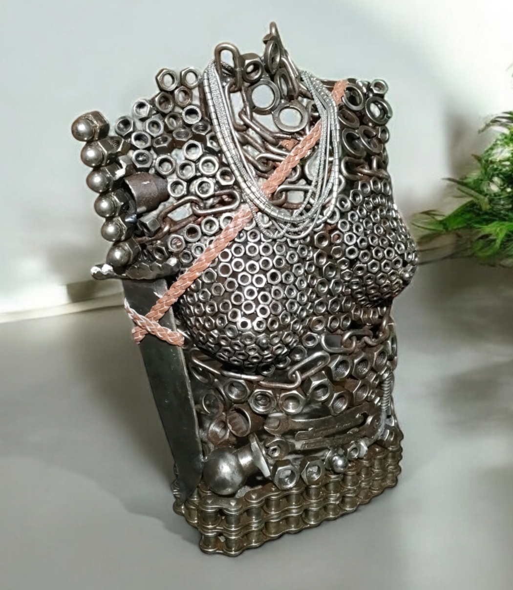 Sculptural metal torso, assembled from nuts, bolts, and chains, with pink and silver accents.
