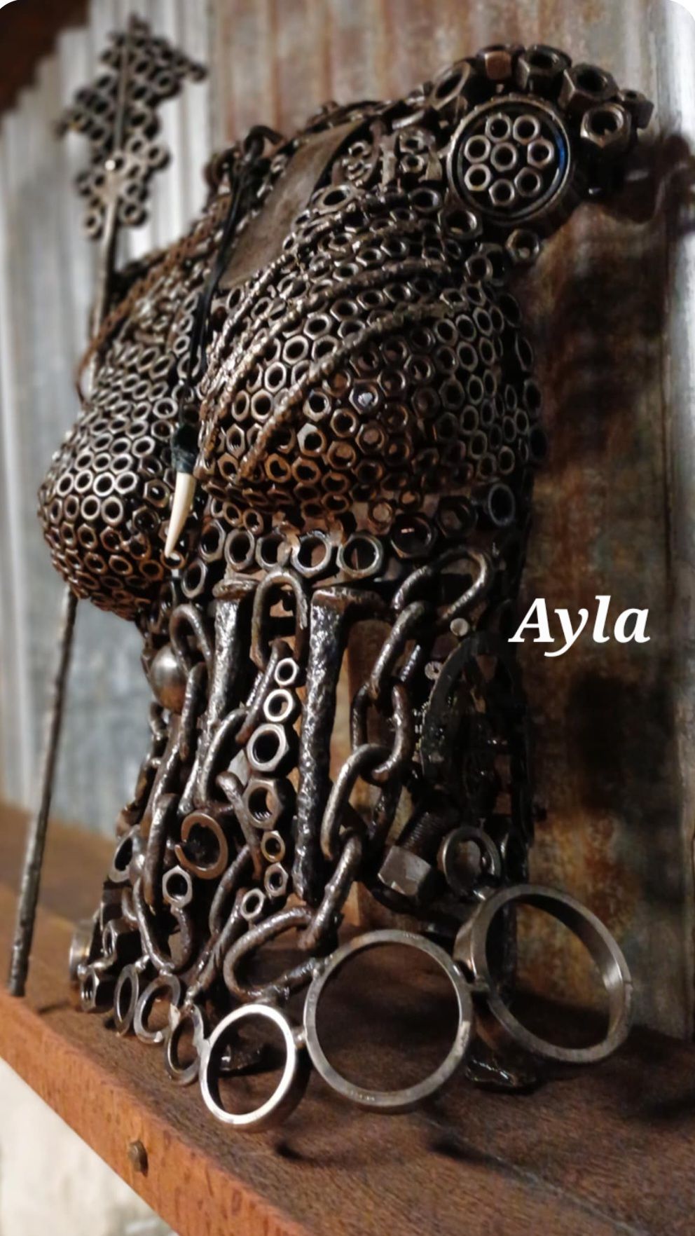 Metal torso sculpture made of scrap metal such as nuts and bolts.