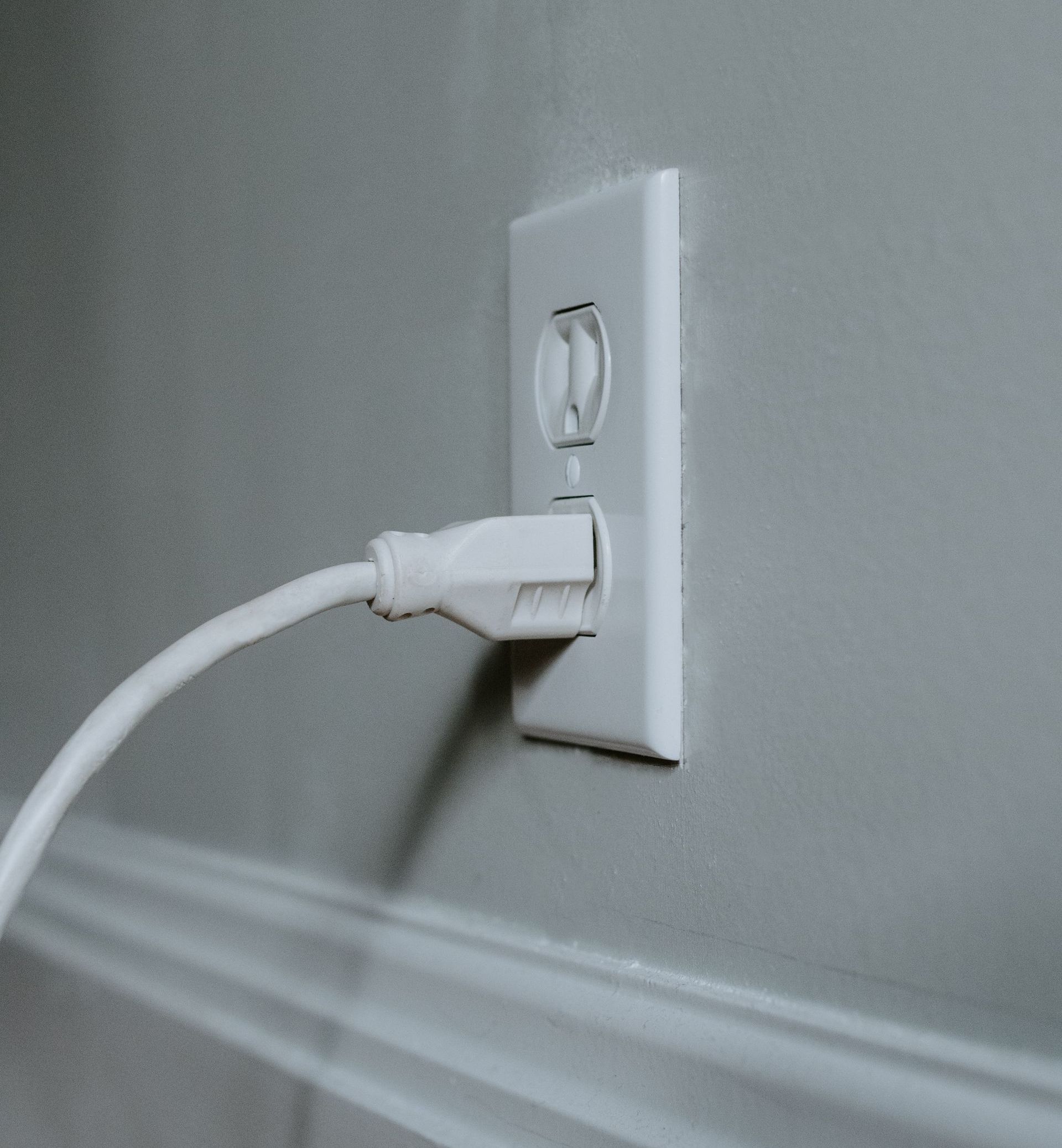 Electrical outlet seamlessly installed in a wall with a plugged cable providing power