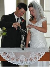 Bride and groom pour sand together into a vase during a wedding ceremony