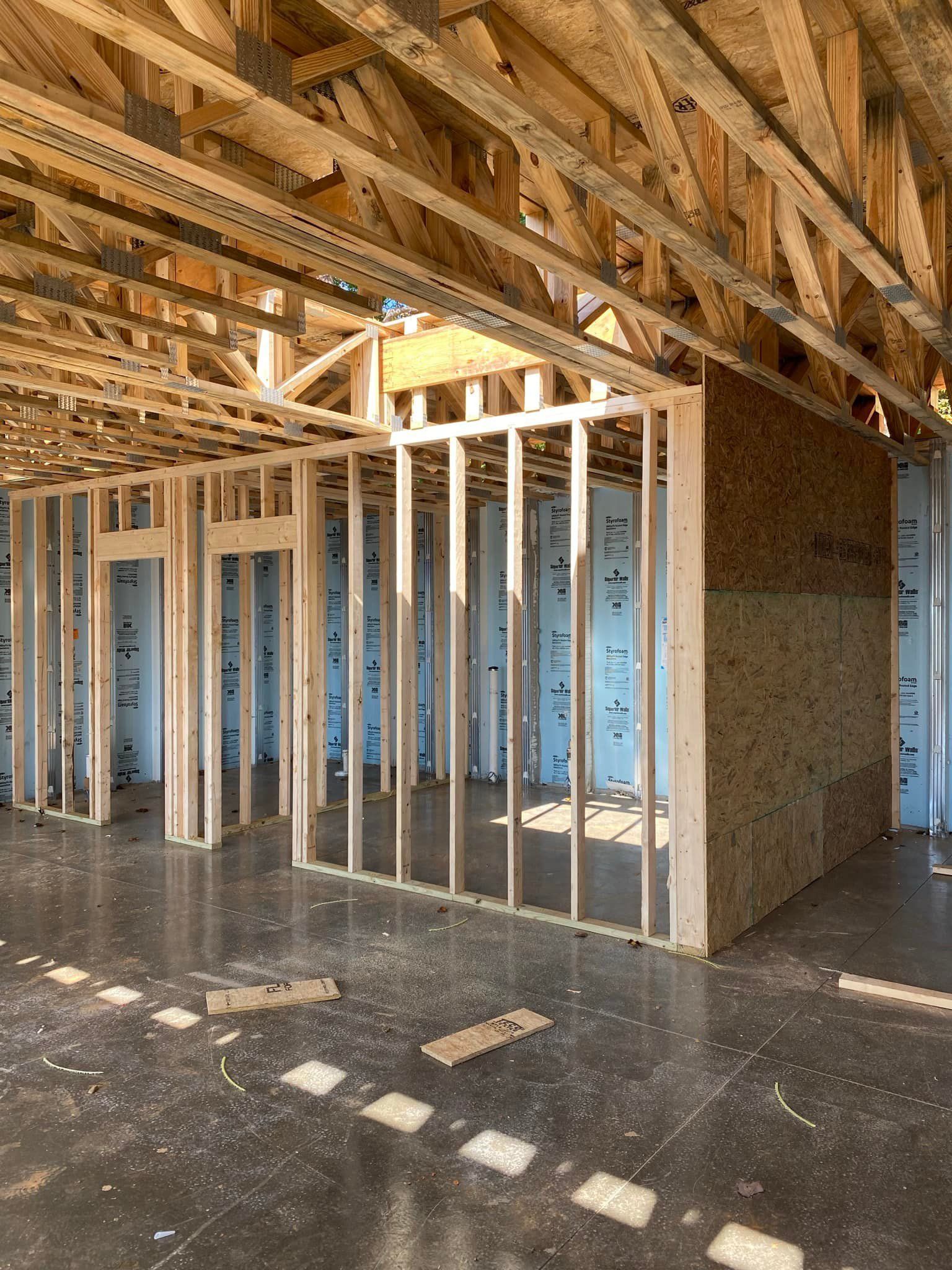 Interior of a building under construction, showing wooden framing and exposed beams.