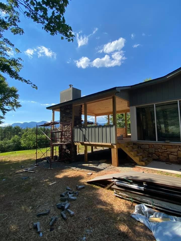 House exterior with a covered deck under construction, with mountain views.