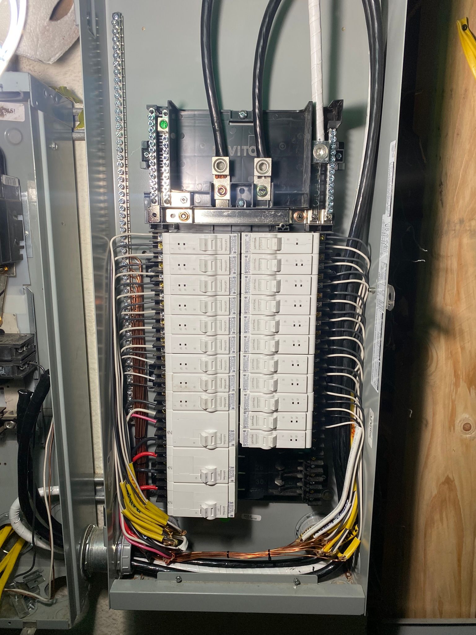 An open electrical panel with a main breaker and multiple circuit breakers.