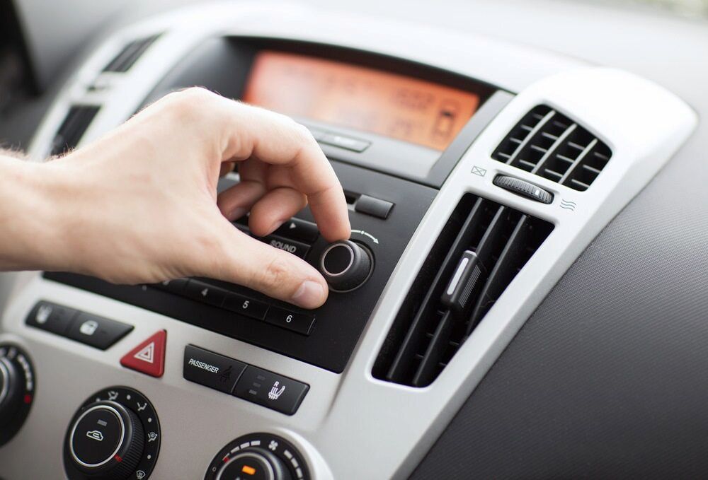 A Person is Adjusting the Radio in a Car — Innisfail Auto Electrics Pty Ltd in Tully, QLD