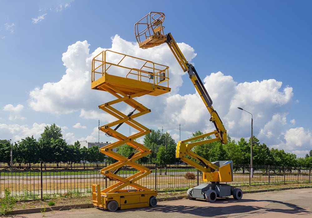 Two Scissor Lifts are Parked Next to Each Other in a Parking lot — Innisfail Auto Electrics Pty Ltd in Tully, QLD