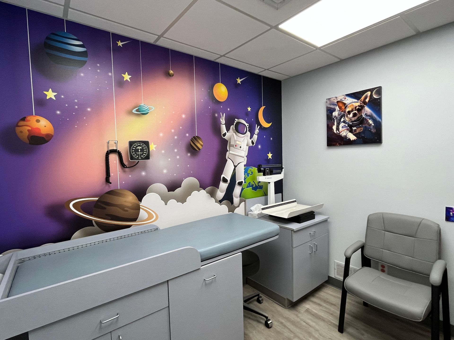 A doctor 's office with a painting of an astronaut on the wall.