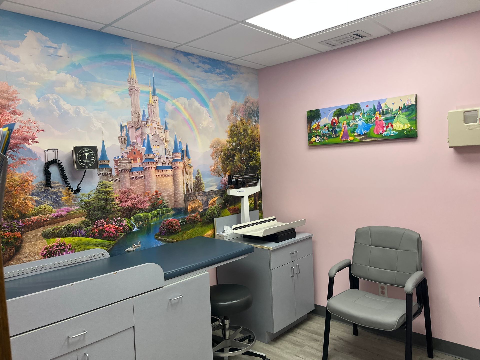 A doctor 's office with a painting of a castle on the wall.