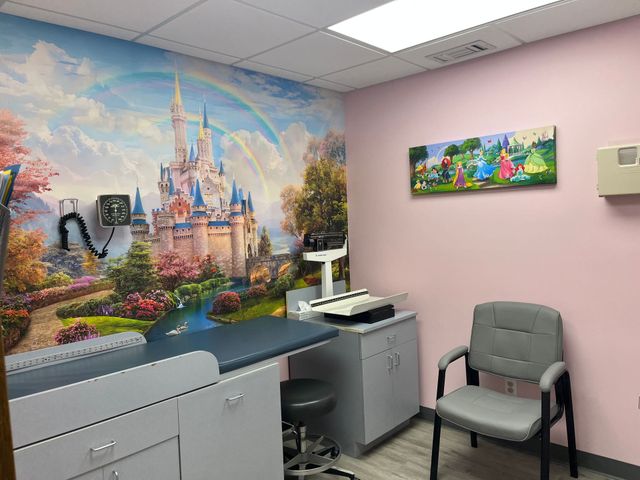 A doctor 's office with a painting of a castle on the wall.