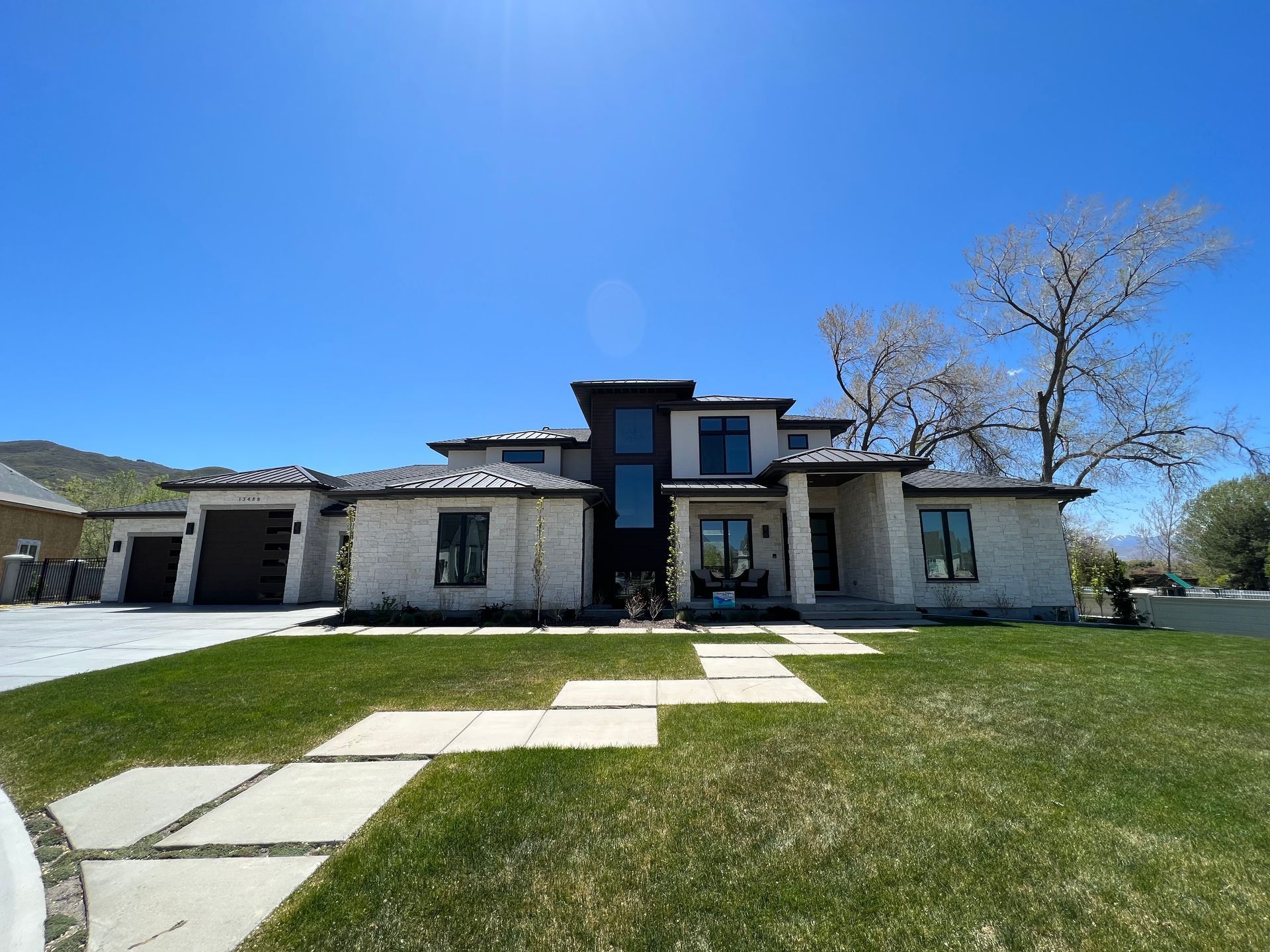 A large white house with a lush green lawn in front of it.