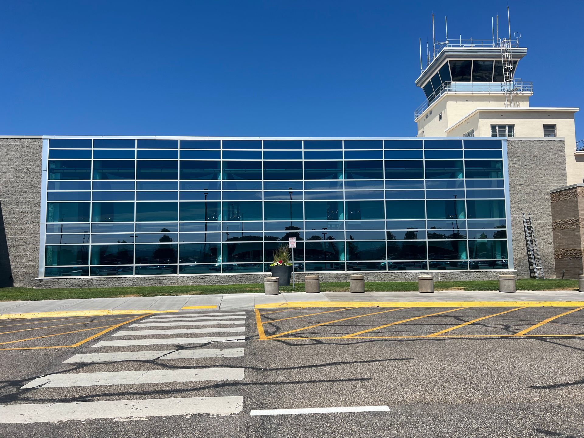 A large glass building with a control tower in the background