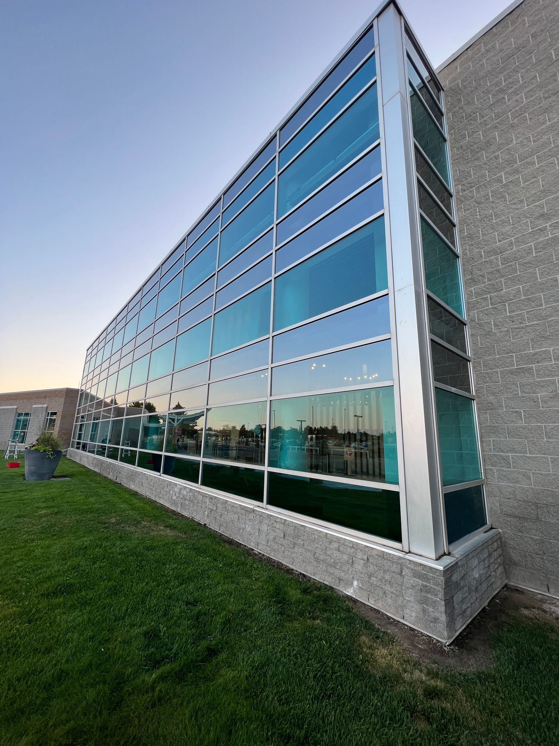 A large building with a lot of windows is surrounded by grass