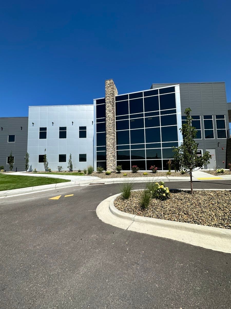 A large building with a lot of windows and a tree in front of it
