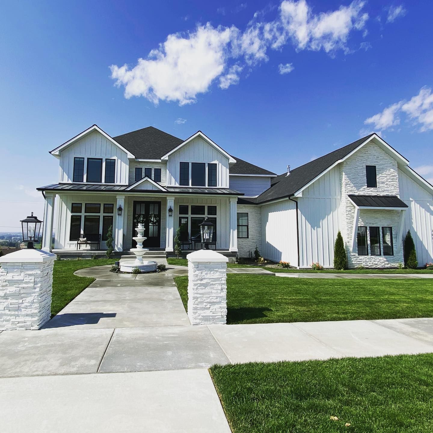 A large white house with a fountain in front of it