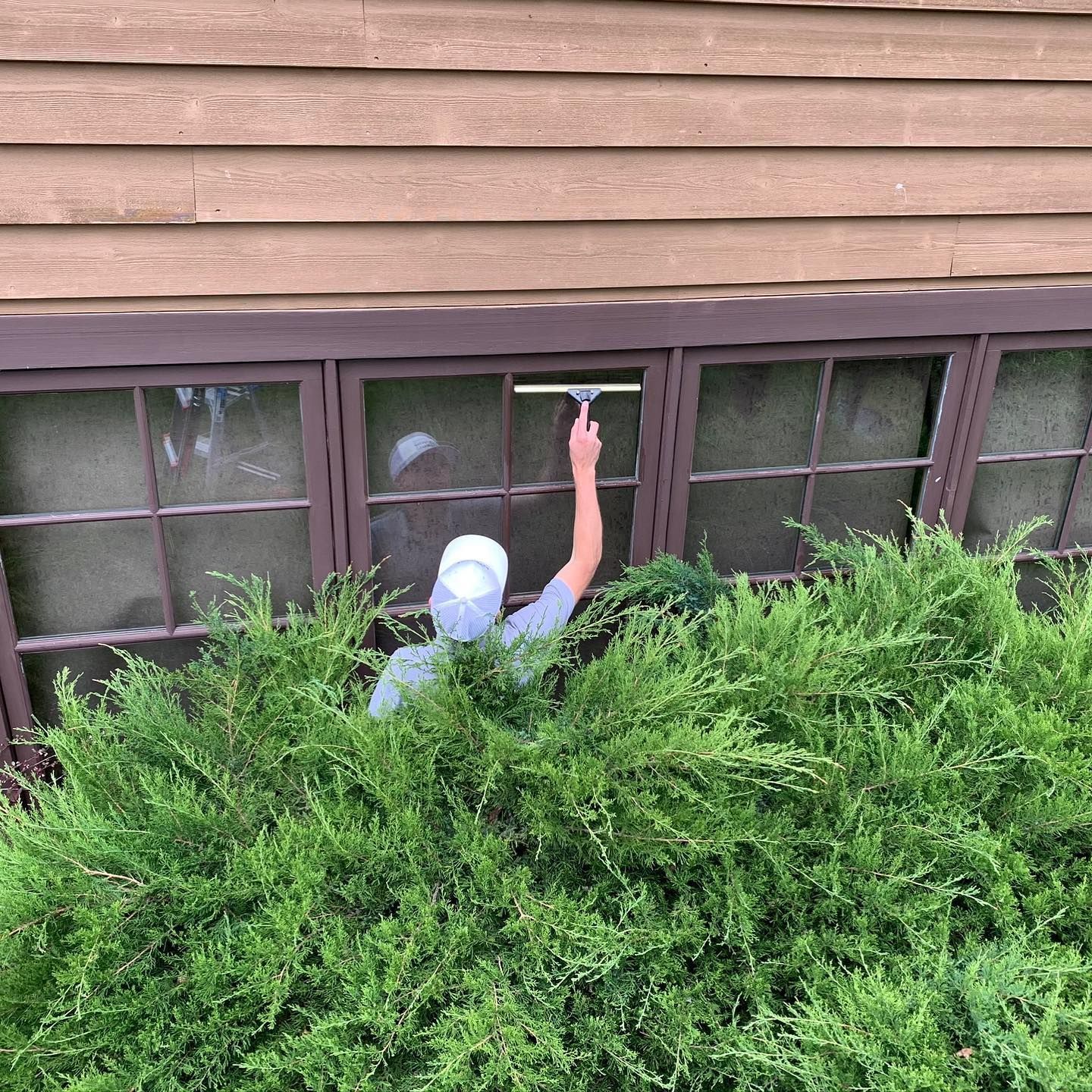 A man is cleaning a window with a squeegee.