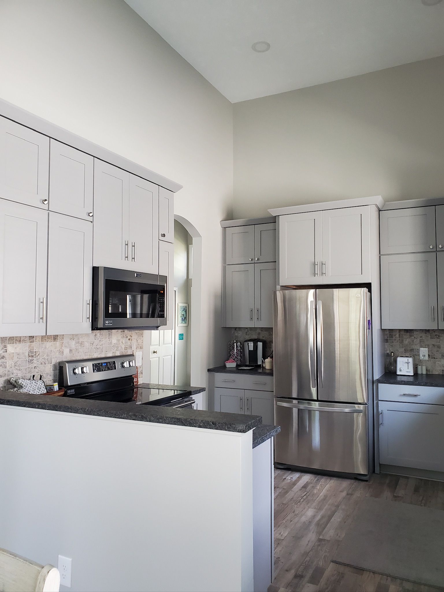 A kitchen with stainless steel appliances and white cabinets.