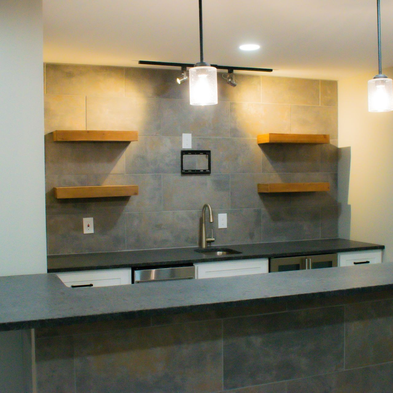 A kitchen with a sink and shelves on the wall