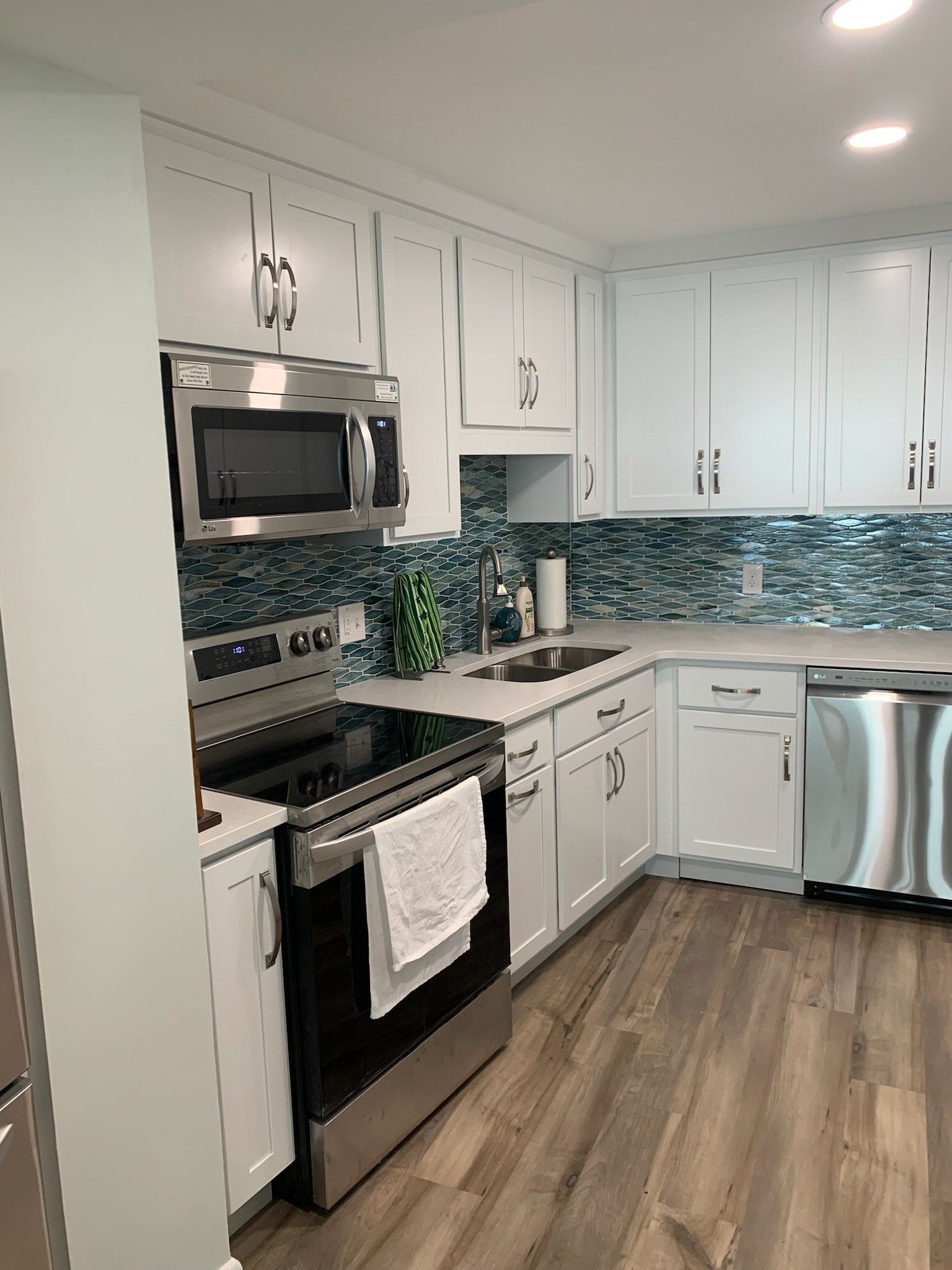 A kitchen with stainless steel appliances and white cabinets.