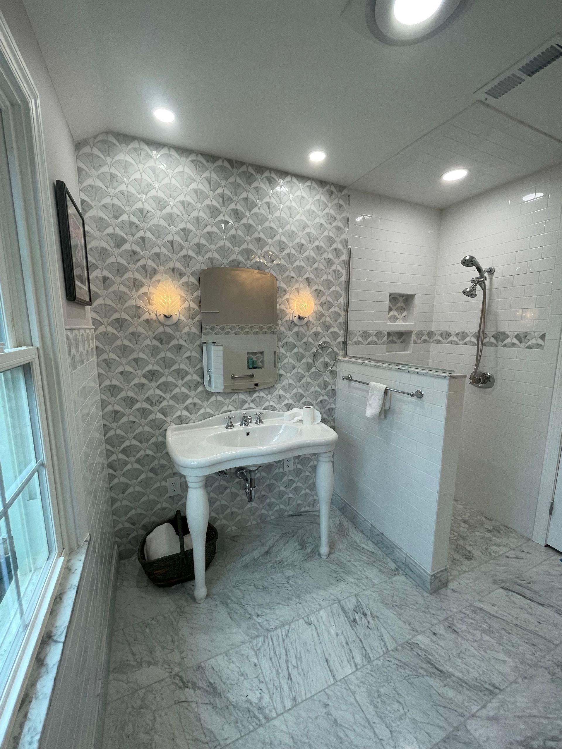 A bathroom with a sink , mirror , and shower.