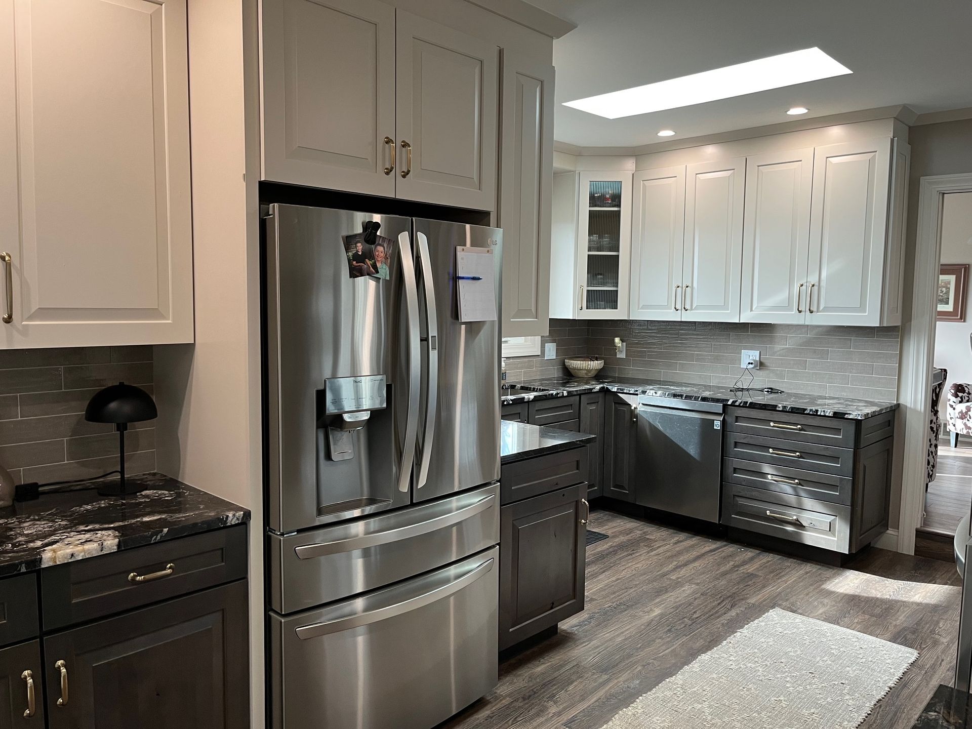 A kitchen with stainless steel appliances and gray cabinets.