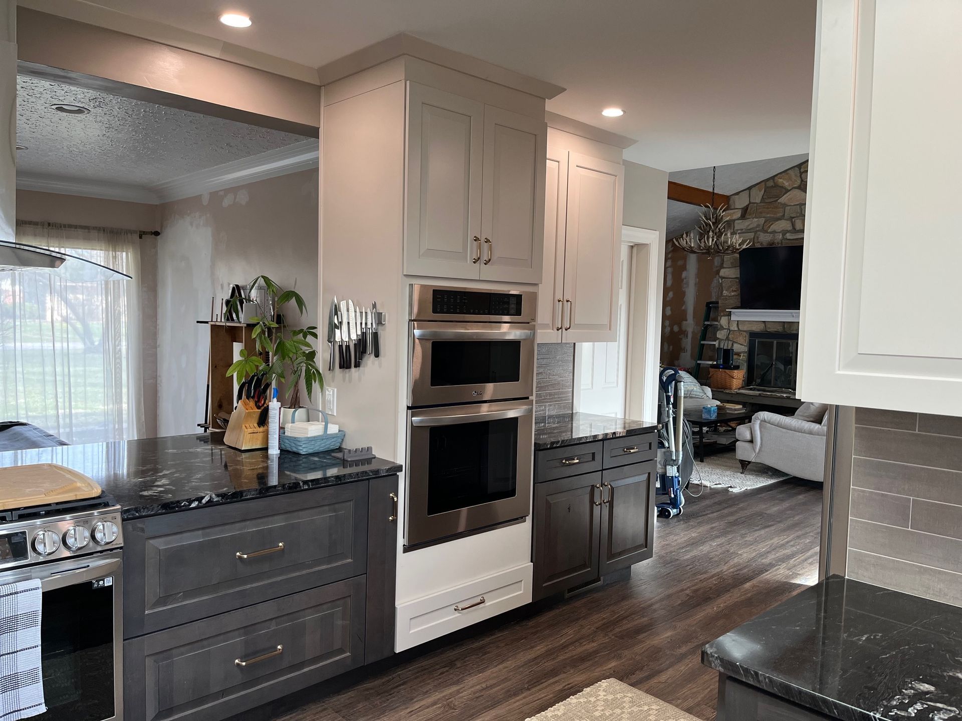 A kitchen with stainless steel appliances and black counter tops.