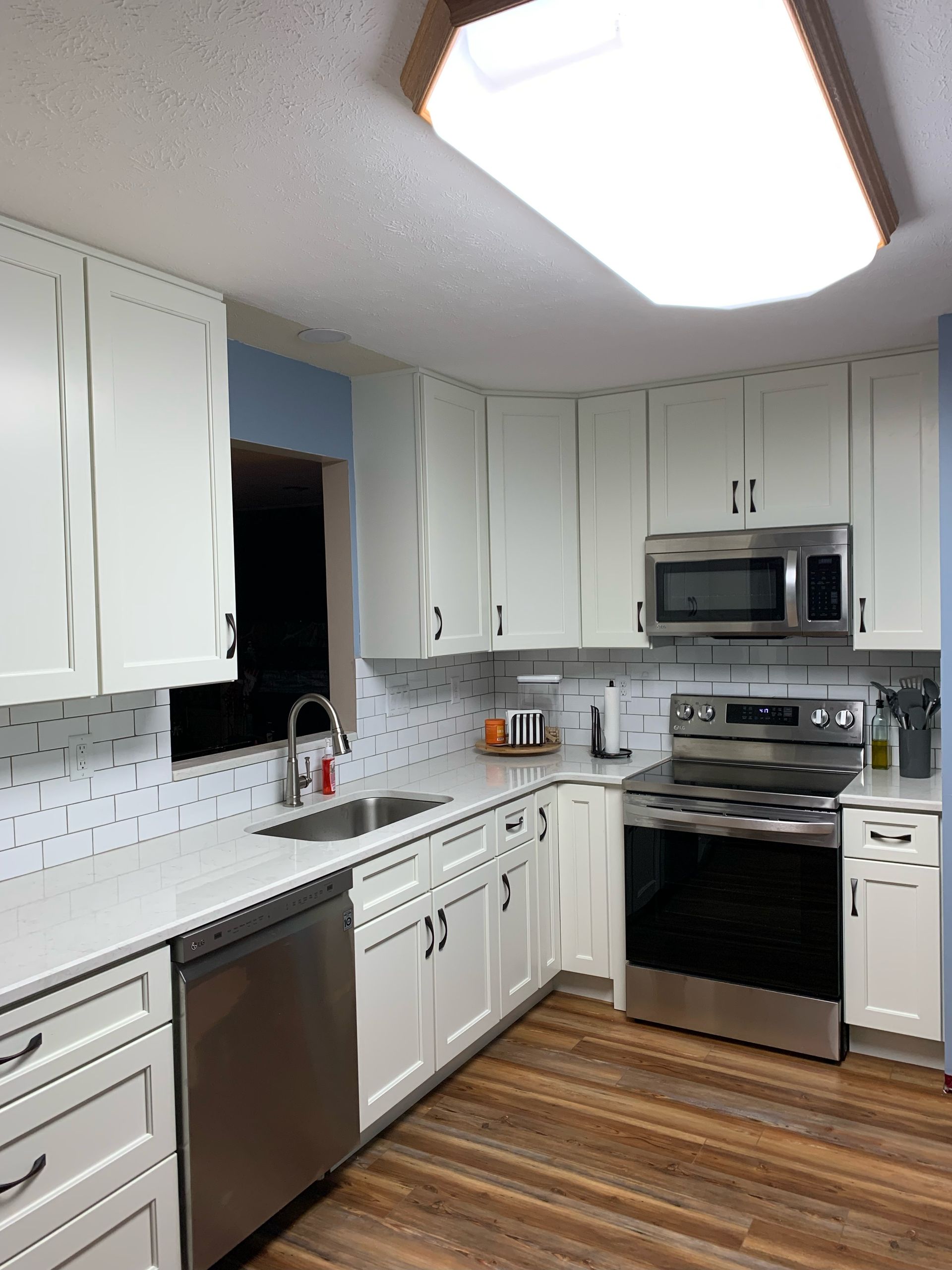 A kitchen with white cabinets and stainless steel appliances