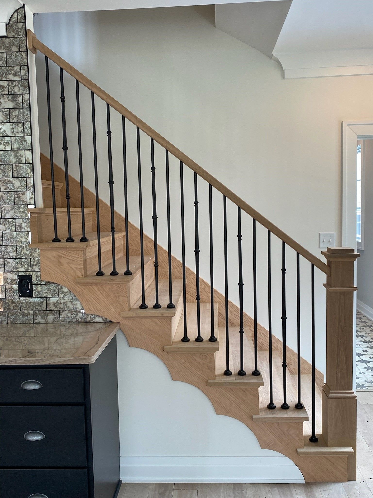 A wooden staircase with a black railing in a house