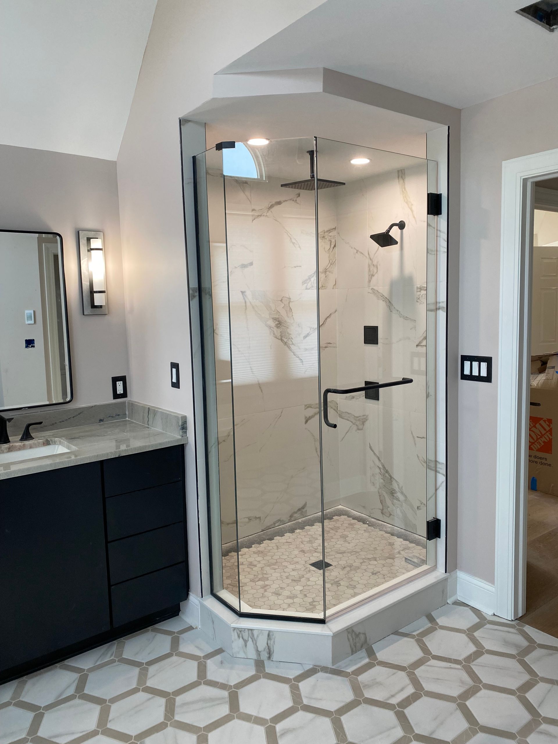 A bathroom with a walk in shower and a sink