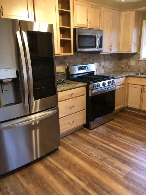 A kitchen with stainless steel appliances and wooden cabinets