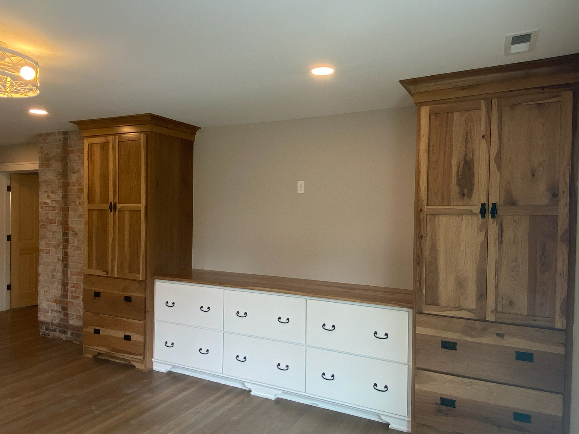 A living room with lots of wooden cabinets and drawers.