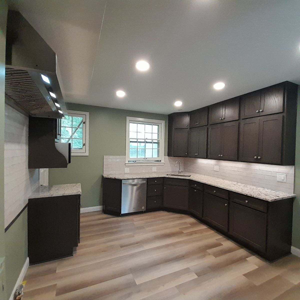 A kitchen with wooden cabinets , granite counter tops , and stainless steel appliances.
