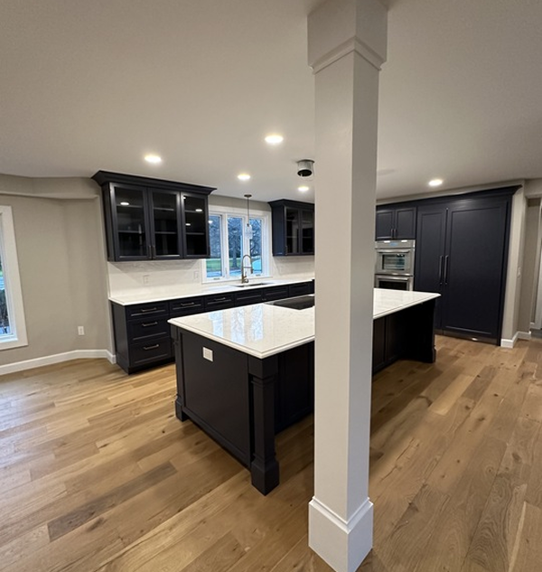 A kitchen with black cabinets and white counter tops