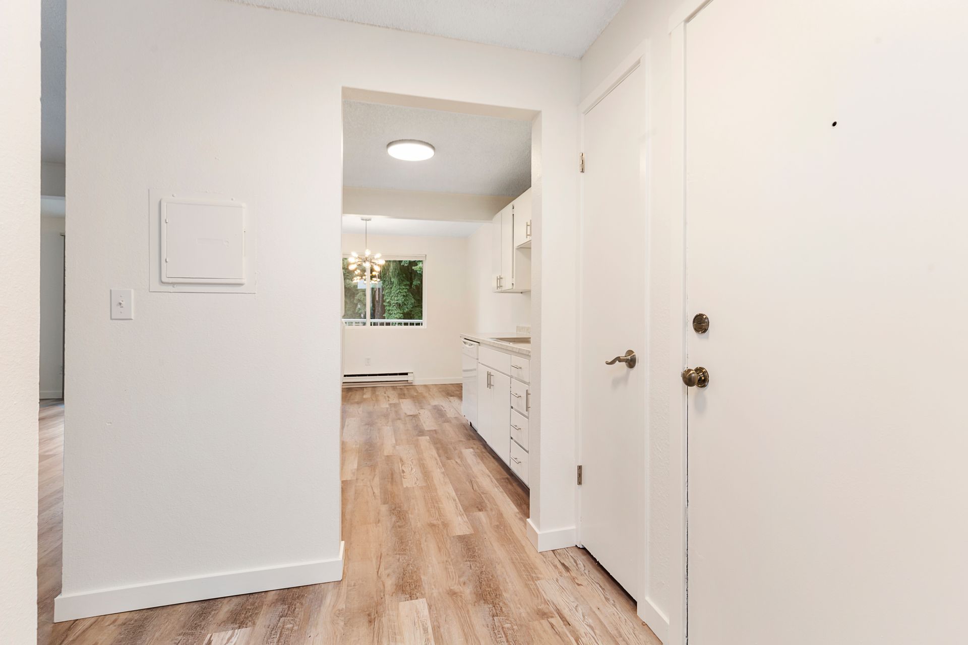 a hallway in a house with hardwood floors and white walls .