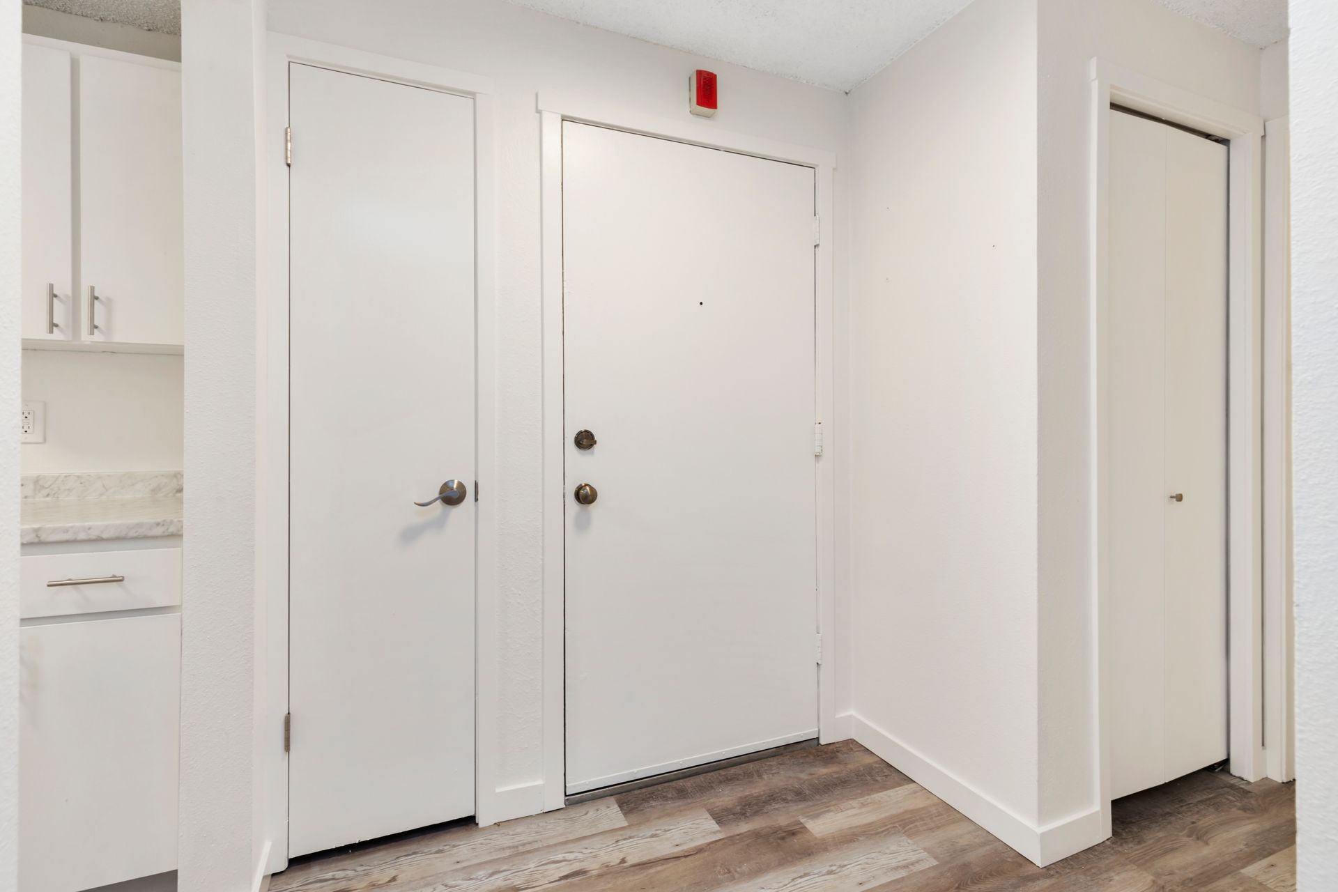 a hallway with a door and a closet in a house .