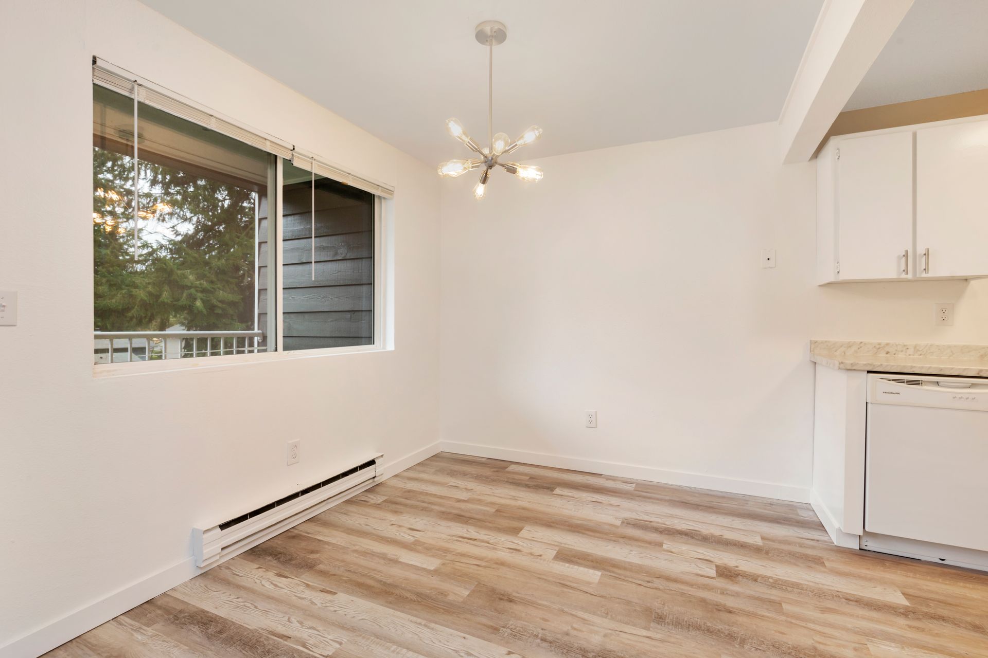 an empty room with a wooden floor and a large window