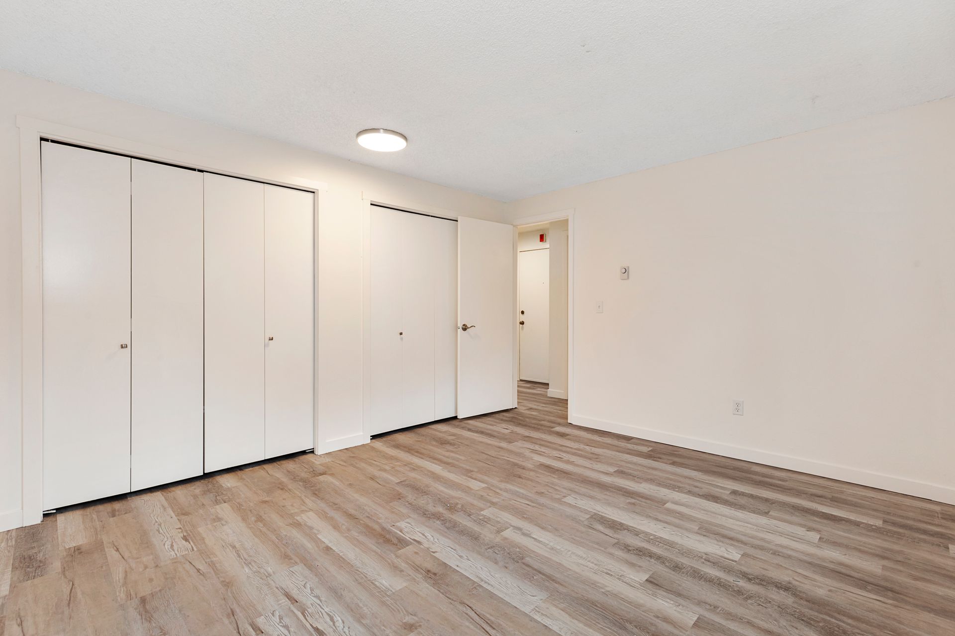 a large empty room with hardwood floors and white walls .