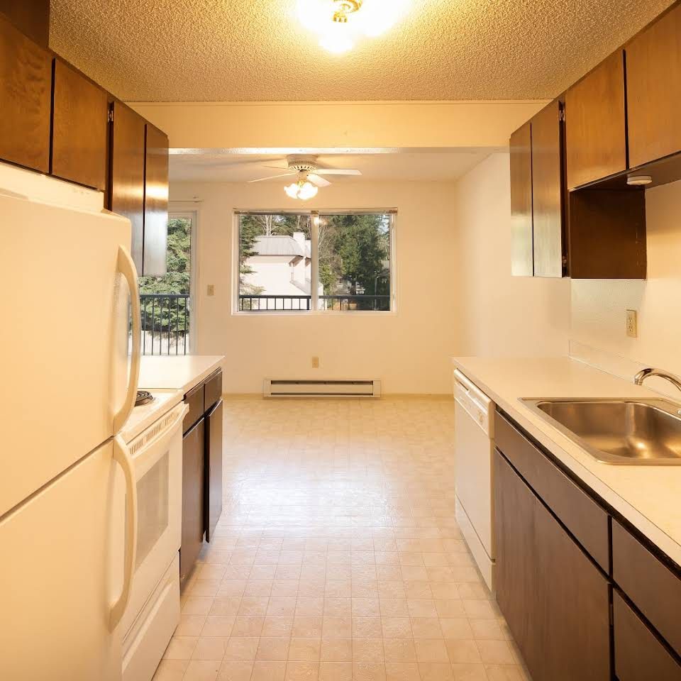 a kitchen with white cabinets and a white refrigerator