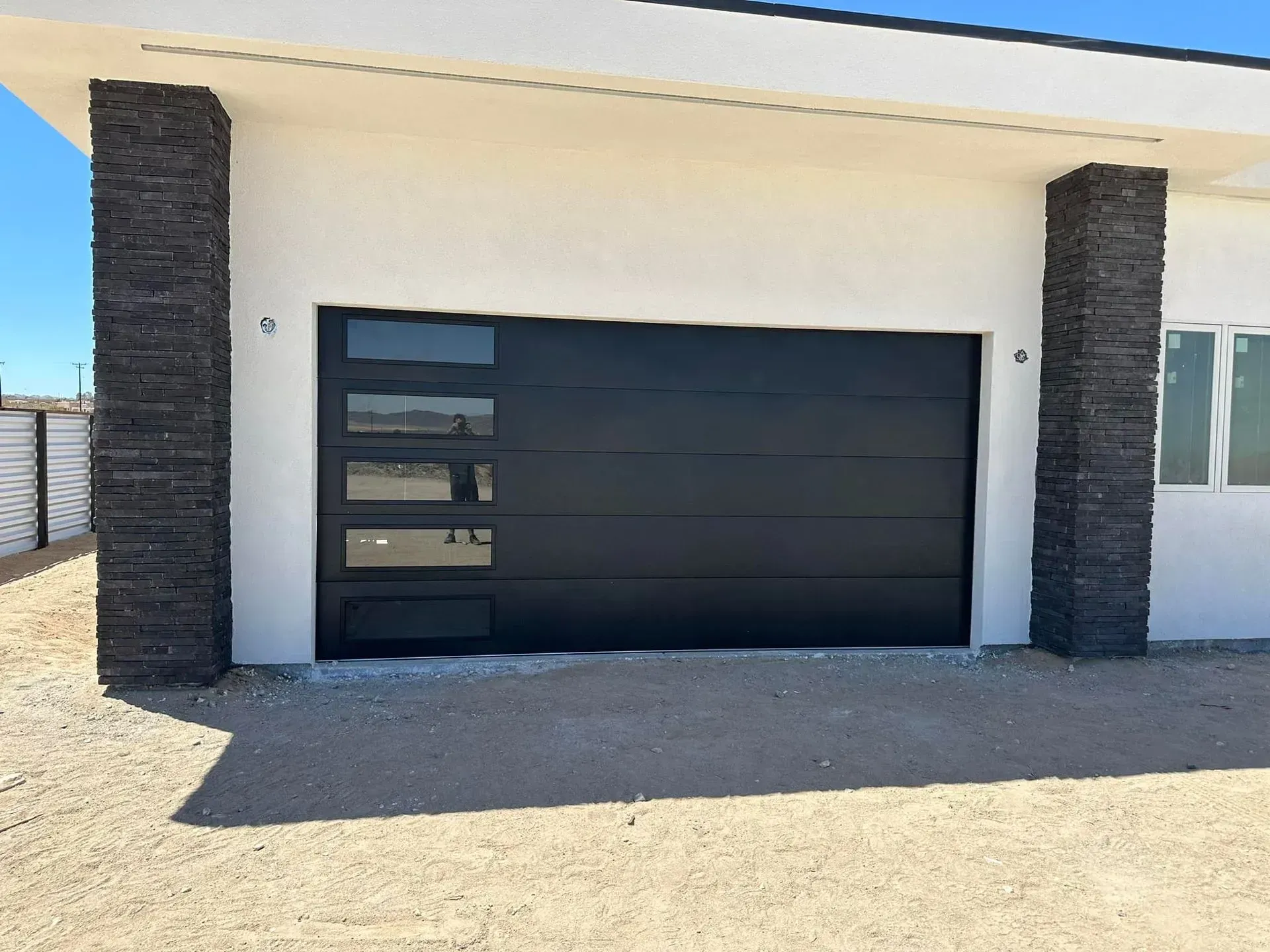 A white house with a black garage door