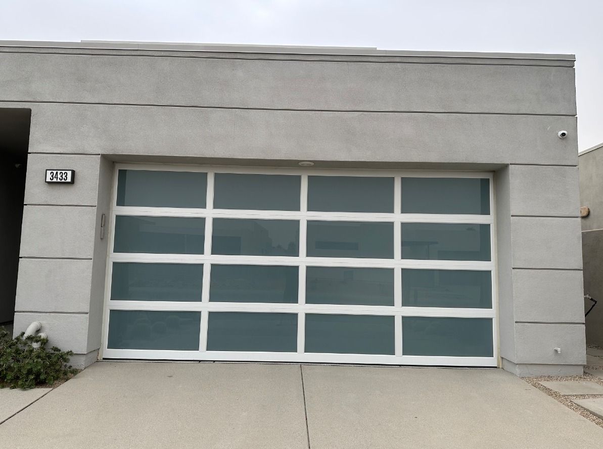 A house with a white garage door has the number 12 on it