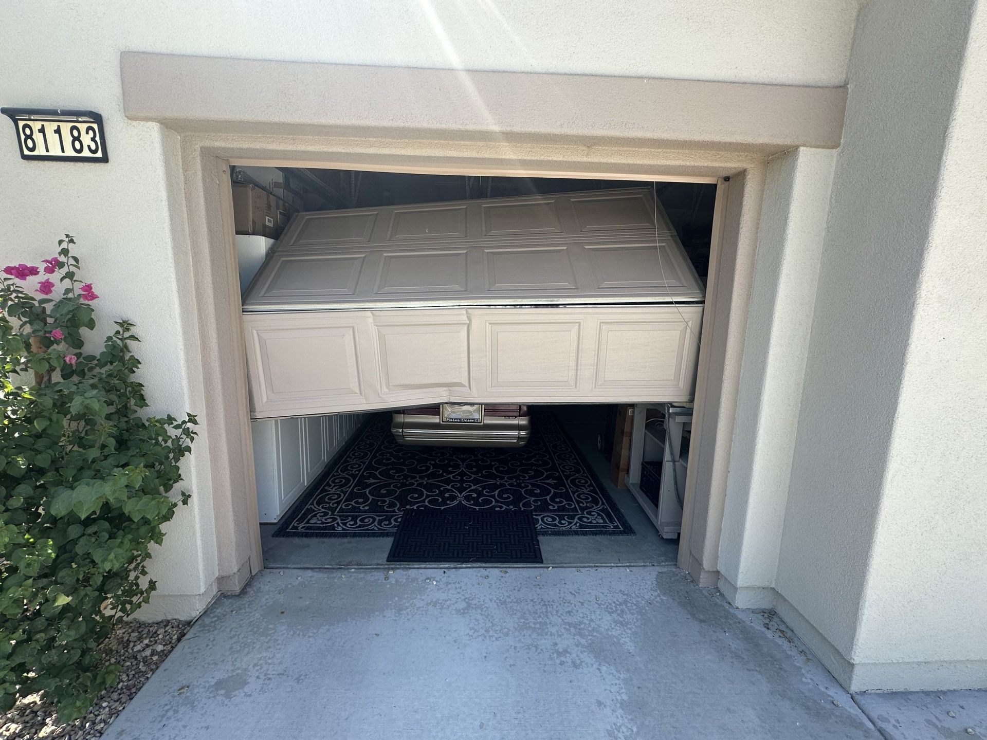 A garage door with the door open and a mattress in it.