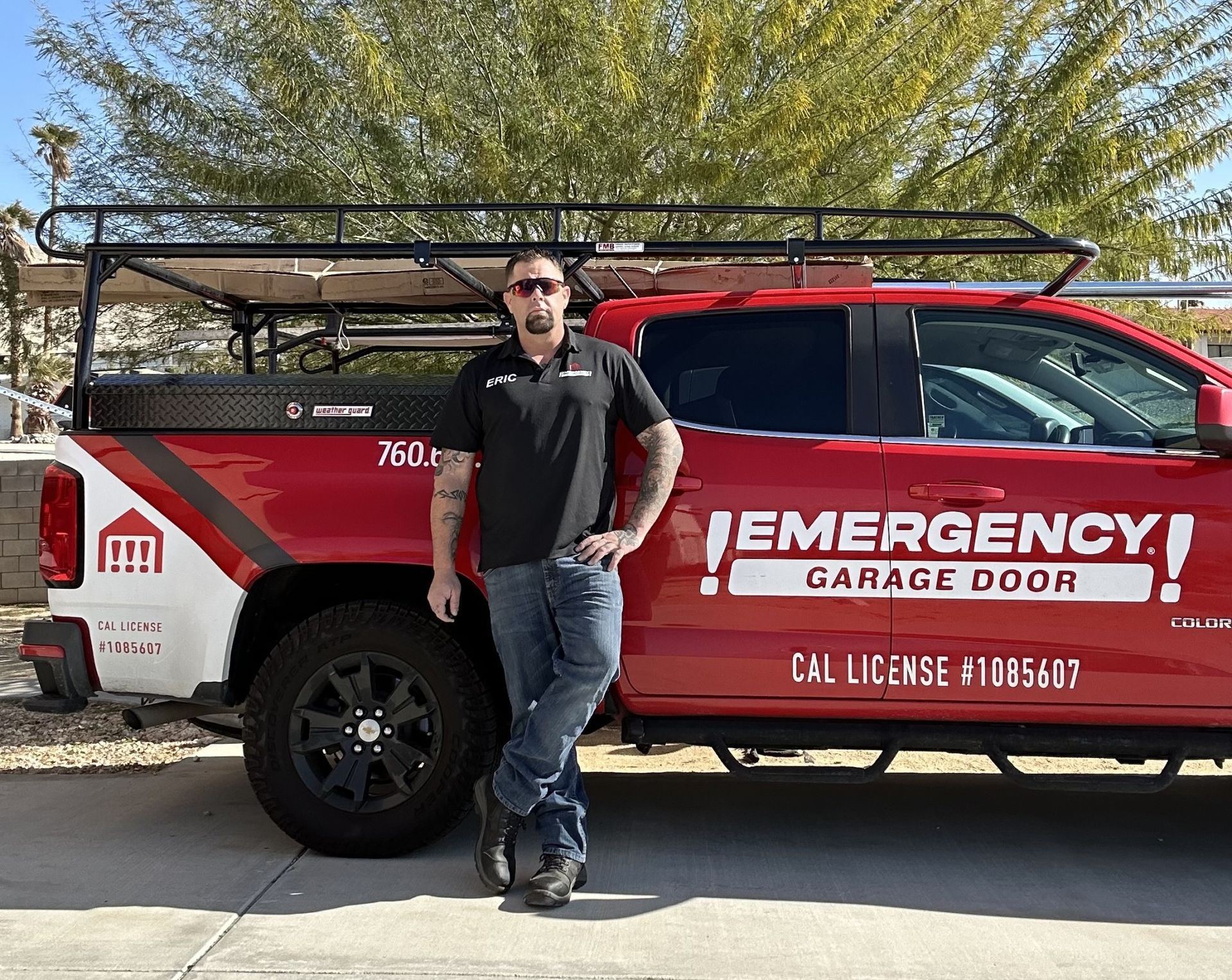 A man is standing in front of an emergency garage door truck.